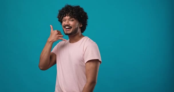 Joven Hombre Indio Sonriente Usando Una Camiseta Rosa Mirando Cámara — Vídeos de Stock