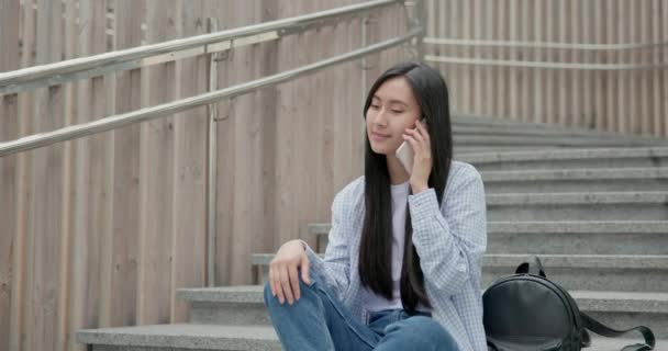 Gülümseyen Asyalı Genç Kız Öğrenci Merdivenlerde Oturuyor Cep Telefonuyla Konuşuyor — Stok video