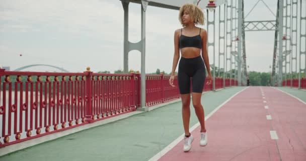 适合年轻的非洲裔美国女人做热身和伸展运动后在桥上慢跑 — 图库视频影像