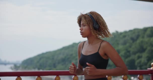 Joven Mujer Afroamericana Corredora Trotando Puente Ciudad Aire Libre — Vídeo de stock