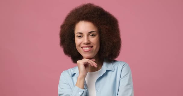 Молода Американка Кучерявим Волоссям Посміхається Дивиться Камеру Стоїть Над Рожевим — стокове відео