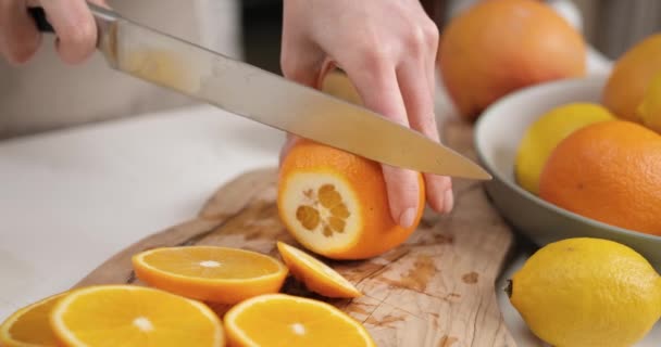女性はナイフでスライス木製のまな板に新鮮な有機オレンジ Dci 二重スローモーション — ストック動画