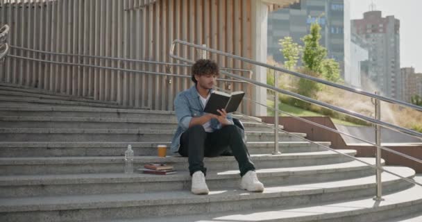 Joven Estudiante Indio Leyendo Libro Sentado Una Escalera Aire Libre — Vídeo de stock