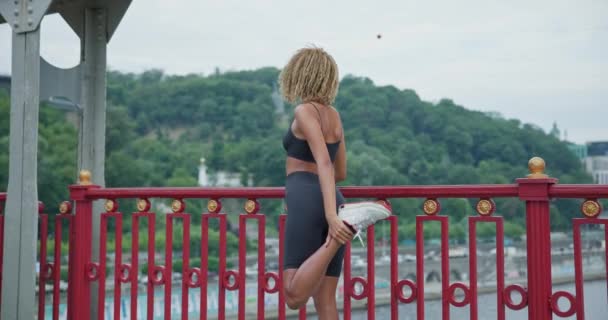 Подходит Молодая Афроамериканская Женщина Разогревается Растягивается Перед Пробежкой Мосту — стоковое видео