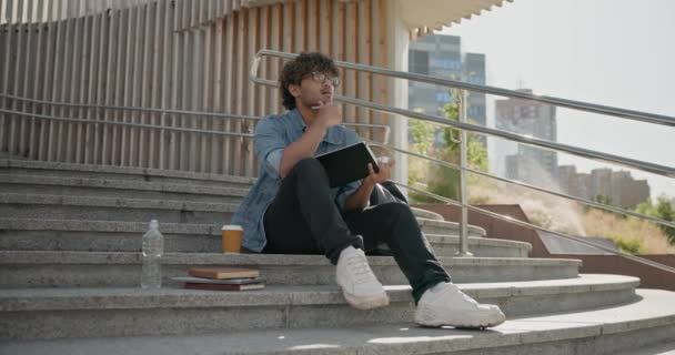 Joven Estudiante Indio Tomando Notas Cuaderno Mientras Está Sentado Una — Vídeos de Stock