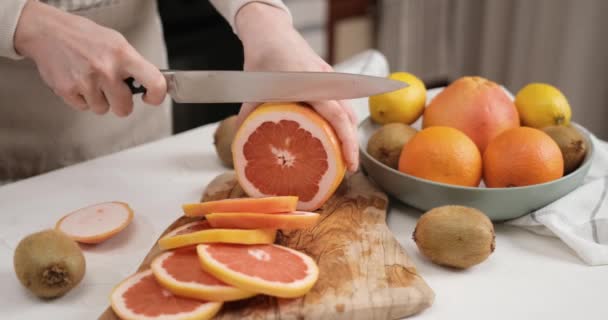 木製の切断板にナイフの新鮮な有機グレープフルーツでスライスした女性 Dciについて スローモーション — ストック動画