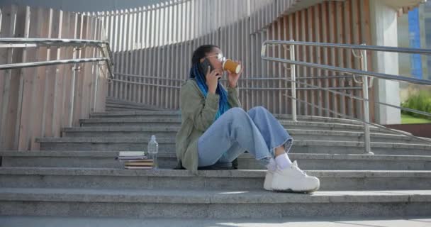 Genç Afro Amerikan Bayan Öğrenci Dışarıda Merdivenlerde Otururken Telefonla Konuşuyor — Stok video