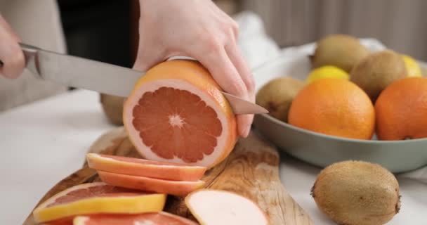 木製の切断板にナイフの新鮮な有機グレープフルーツでスライスした女性 Dciについて スローモーション — ストック動画