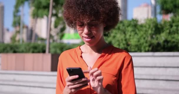 곱슬머리의 아프리카 미국인 스마트폰을 서핑을 온라인 데이트 미디어를 모바일 사용하는 — 비디오