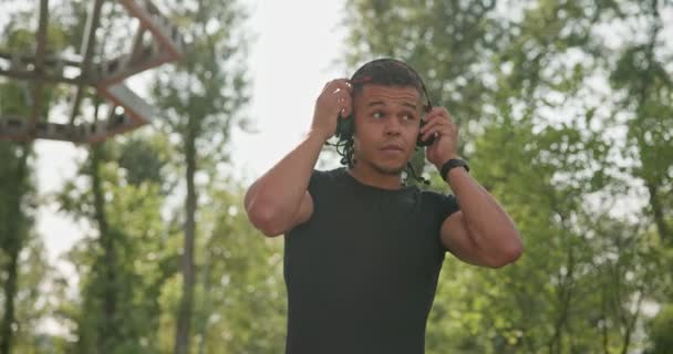Νεαρός Αθλητικός Αφρικάνος Αμερικανός Τύπος Σπορ Περπάτημα Ακουστικά Απολαμβάνοντας Ακούγοντας — Αρχείο Βίντεο