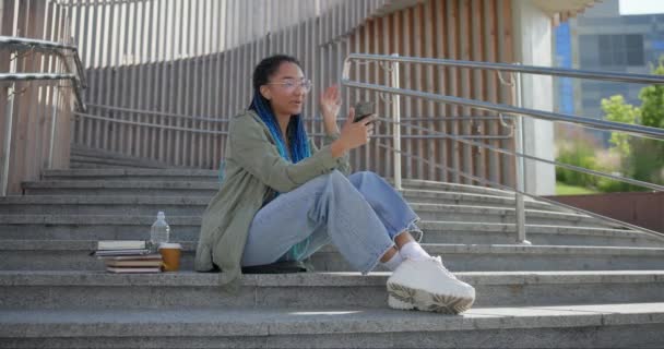 Молода Афроамериканська Студентка Робить Відеодзвінок Мобільний Телефон Сидячи Відкритому Повітрі — стокове відео