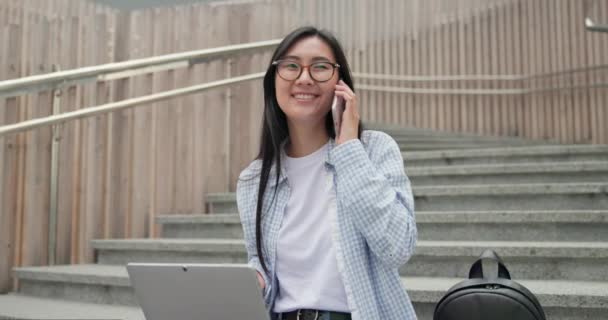 Lächelnde Junge Studentin Sitzt Mit Laptop Auf Der Treppe Und — Stockvideo