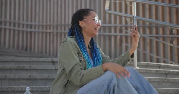 Νεαρή Αφροαμερικανή Φοιτήτρια Που Κάνει Βιντεοκλήση Στο Κινητό Ενώ Κάθεται — Αρχείο Βίντεο