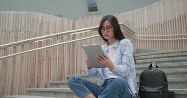 Dışarıdaki Merdivenlerde Otururken Tablet Tablet Kullanan Genç Asyalı Kız Öğrenci — Stok video