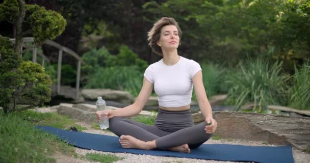 Jonge Blanke Vrouw Sportkleding Zit Yoga Mat Buiten Drinkwater Tijdens — Stockvideo