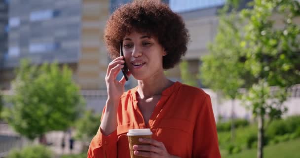 Νεαρή Αφροαμερικανή Γυναίκα Σγουρά Μαλλιά Μιλώντας Ένα Τηλέφωνο Πόδια Εξωτερική — Αρχείο Βίντεο