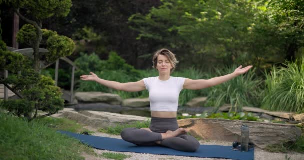Junge Kaukasische Frau Sportbekleidung Sitzt Auf Yogamatte Freien Und Meditiert — Stockvideo