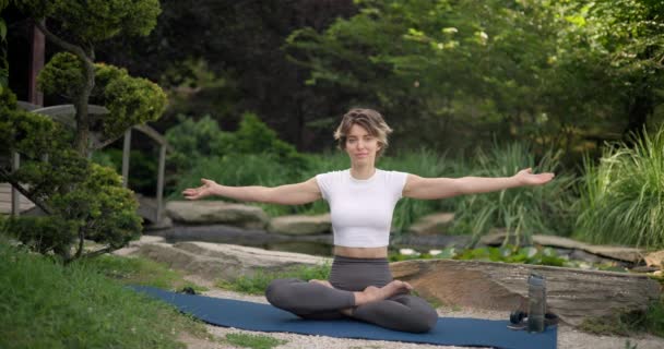 Jonge Blanke Vrouw Sportkleding Zit Yoga Mat Buiten Mediteren — Stockvideo