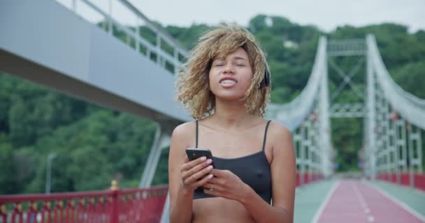 Молодая Африканская Американка Наушниках Выбирает Музыку Телефону Перед Пробежкой Городском — стоковое видео