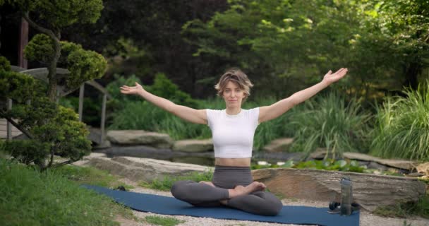 Junge Kaukasische Frau Sportbekleidung Sitzt Auf Yogamatte Freien Und Meditiert — Stockvideo