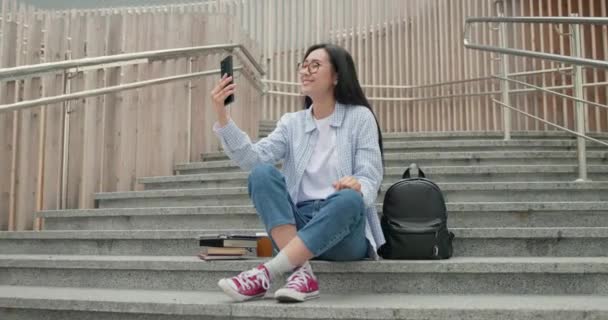 Smiling Asian Young Student Female Seats Stairs Talking Mobile Phone — Stock Video
