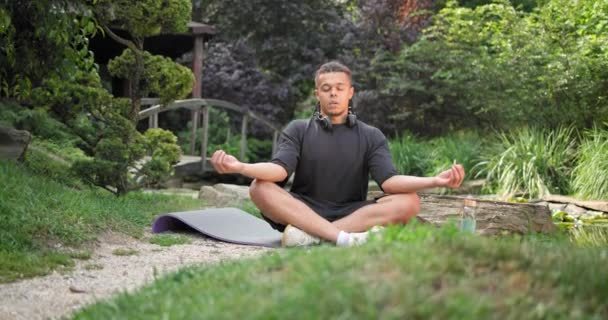 Молодой Африканский Американец Духовности Мужчина Медитирует Йога Асана Сидя Парке — стоковое видео