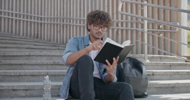 Junge Indische Kerl Student Buch Lesen Sitzt Auf Einer Treppe — Stockvideo
