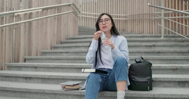 Giovane Asiatico Donna Studente Bere Acqua Mentre Seduta All Aperto — Video Stock