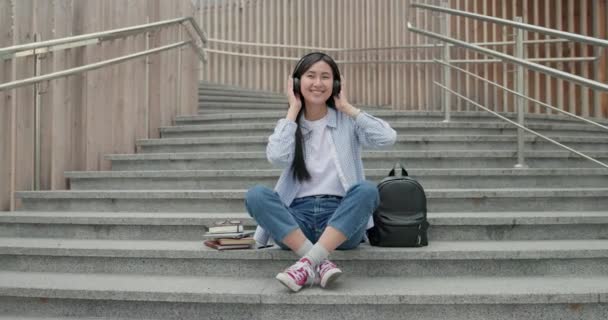 Привлекательная Молодая Азиатка Слушающая Музыку Наушниках Пользуется Смартфоном Городе Сидя — стоковое видео