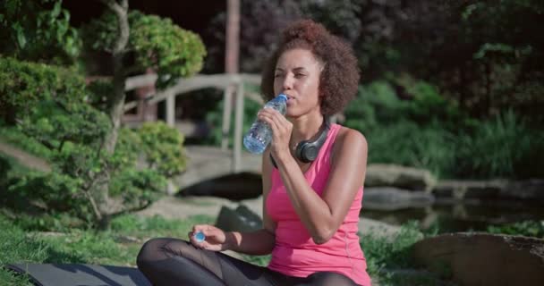 Jovem Mulher Afro Americana Senta Uma Posição Lótus Água Potável — Vídeo de Stock