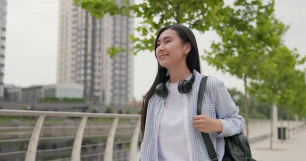 魅力的な若いアジアの女性と街を歩くヘッドフォン — ストック動画