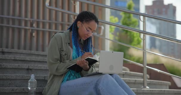 Genç Afrikalı Amerikalı Kadın Öğrenci Dışarıda Merdivenlerde Otururken Deftere Notlar — Stok video