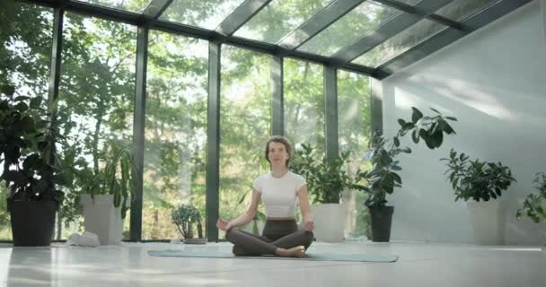 Junge Kaukasische Fitness Frau Sitzt Lotusposition Auf Einer Yogamatte Einem — Stockvideo