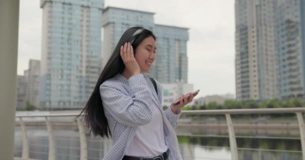 Привлекательная Молодая Азиатка Наушниках Гуляет Городу — стоковое видео