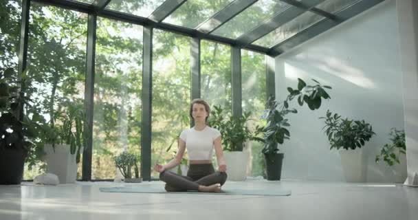Joven Mujer Fitness Caucásica Sentada Posición Loto Una Esterilla Yoga — Vídeo de stock