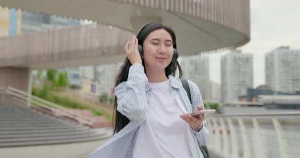 Aantrekkelijke Jonge Aziatische Vrouw Met Koptelefoon Lopen Stad — Stockvideo