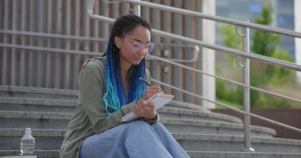 Giovane Studentessa Afroamericana Che Prende Appunti Scrivendo Quaderno Mentre Seduta — Video Stock