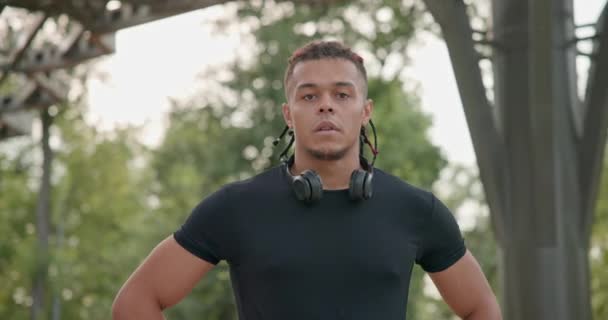 疲れたアフリカ系アメリカ人選手は屋外でジョギングした後呼吸を回復し休息する 二重スローモーション — ストック動画