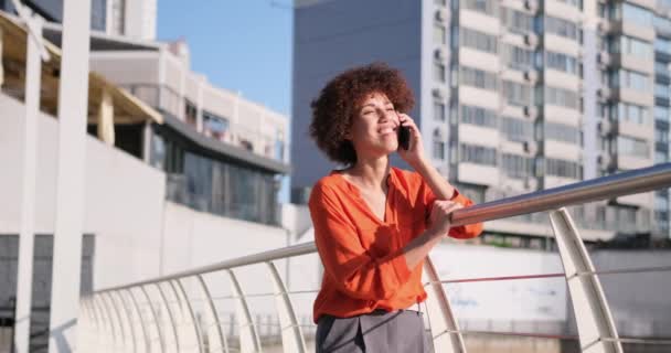 Молодая Афроамериканка Вьющимися Волосами Разговаривает Телефону Гуляя Свежем Воздухе Современном — стоковое видео