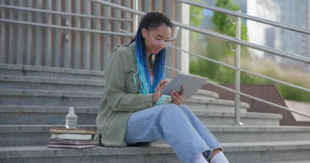 年轻的非洲裔美国女学生或自由职业者在网上学习或在室外使用平板电脑垫远程工作 — 图库视频影像