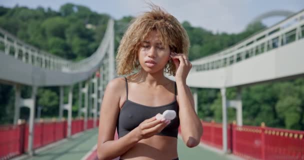 Młoda Afroamerykanka Zakłada Słuchawki Przed Bieganiem Świeżym Powietrzu Moście Miejskim — Wideo stockowe