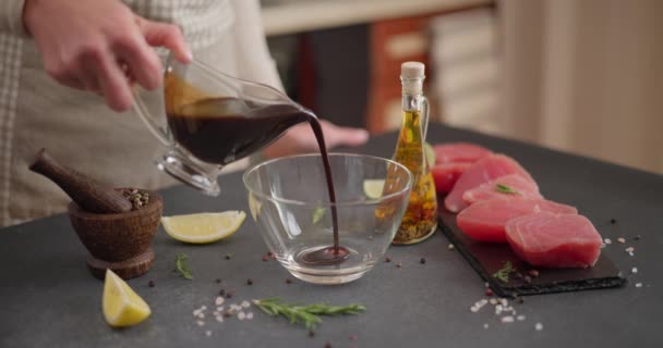 テリヤキ醤油をボウルに注ぎ 新鮮なマグロの詰め物を作るためにマリネードを準備する女性 Dciについて — ストック動画