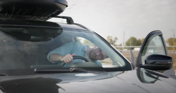 Joven Hombre Caucásico Sienta Detrás Del Volante Coche Estacionamiento Examina — Vídeos de Stock