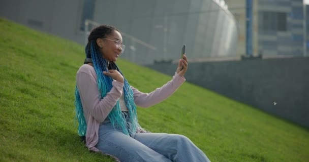 안경을 아프리카계 미국인 여자는 화창한 잔디에 비디오 통화를 이야기 — 비디오