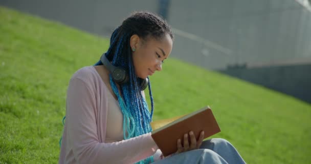 Atractiva Joven Afroamericana Con Rastas Leyendo Libro Sentado Césped Hierba — Vídeos de Stock