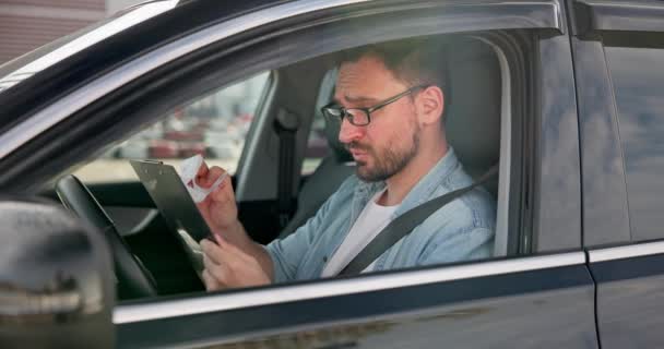 悲しい怒りの男が車に座って 彼に発行された請求書や小切手を見ます Dciについて — ストック動画
