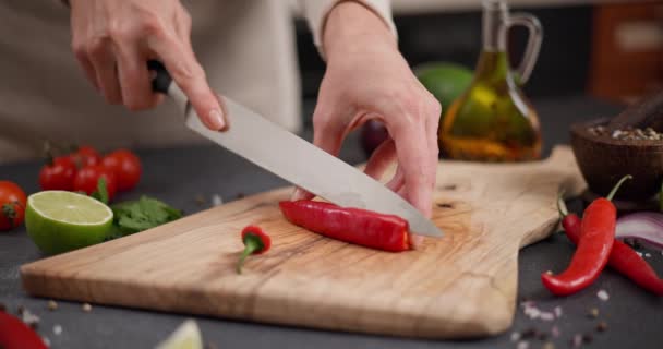 Mulher Cortando Pimenta Vermelha Quente Uma Tábua Corte Madeira Cozinha — Vídeo de Stock