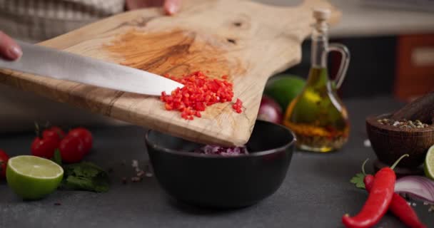 Mulher Derramando Pimentão Picado Quente Vermelho Tigela Cerâmica Preta Cozinha — Vídeo de Stock