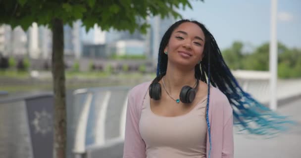 美丽而时尚的年轻非洲裔美国女人的肖像 她带着恐惧的头发 看着镜头慢镜头 微笑着 — 图库视频影像