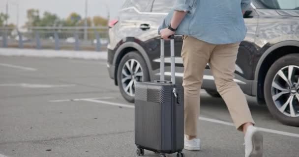 スーツケースを持った若者が車のトランクにやってくる Dciについて — ストック動画